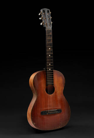 Brown acoustic guitar stood up