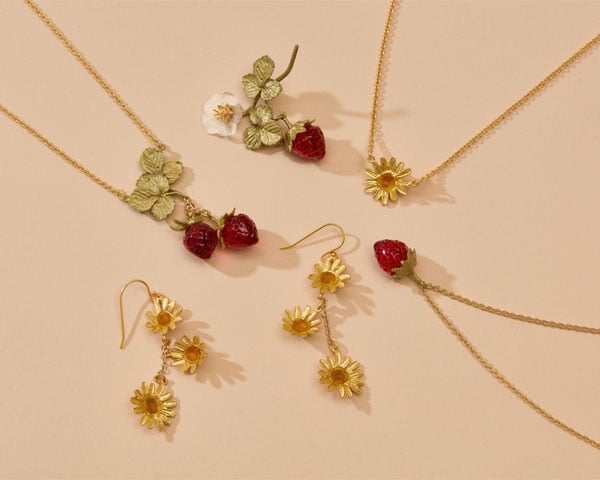 Earrings, necklaces and brooches with summer floral and fruit motifs.